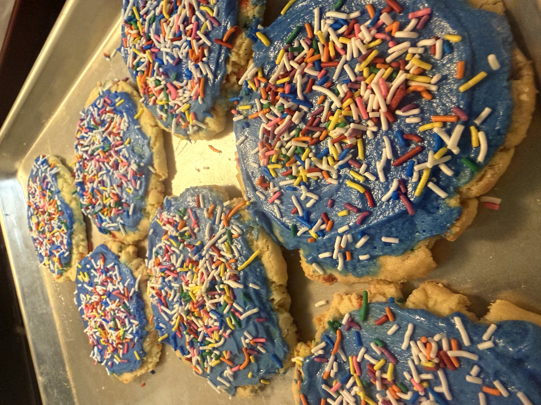 Frosted sugar cookies covered in rainbow sprinkles