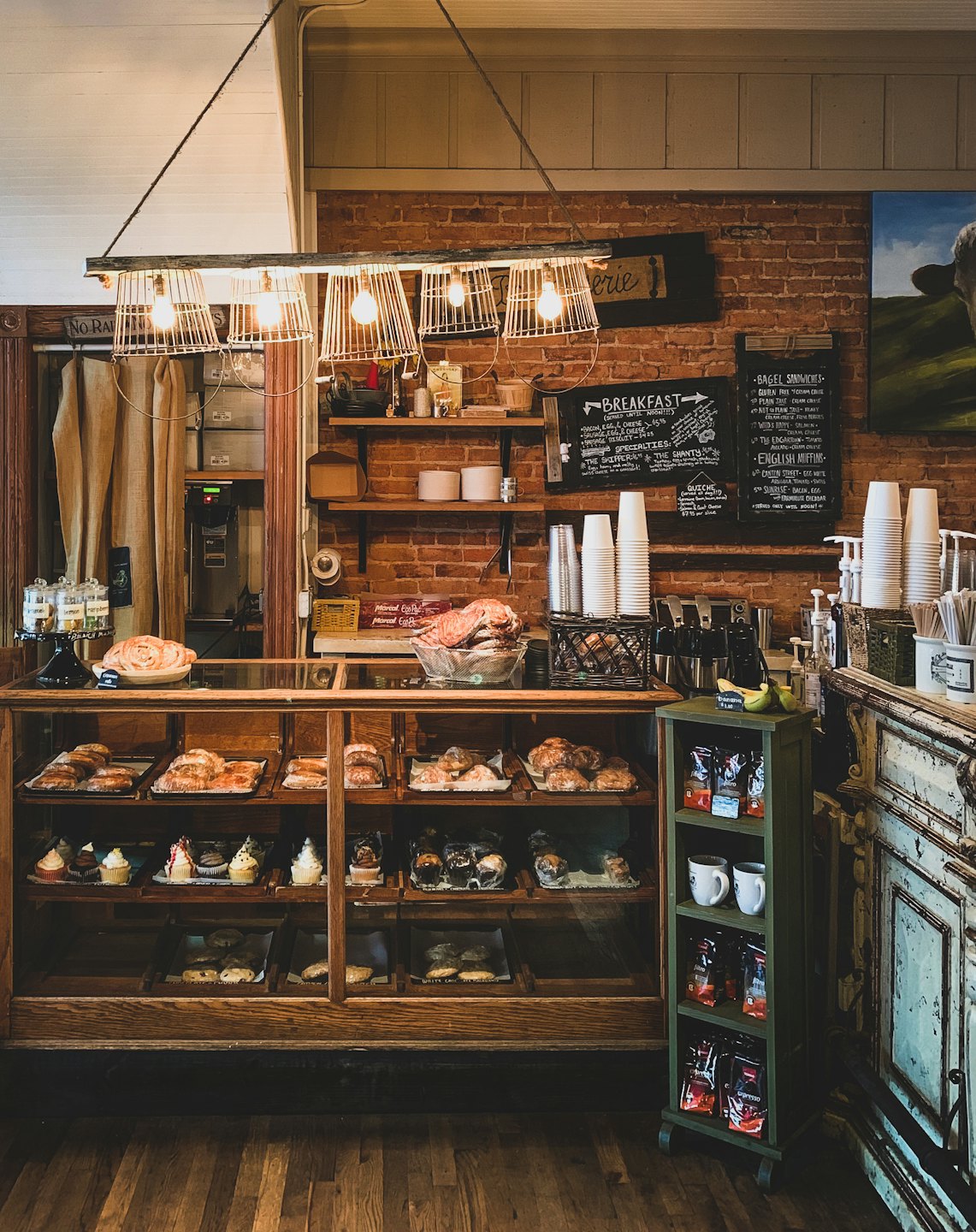 Pastries and muffins displayed in a wooden bakery counter.